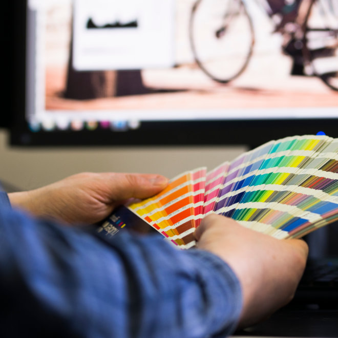 Mężczyzna trzymający próbki kolorów dla klienta w ramach oferowanej usługi studia graficznego